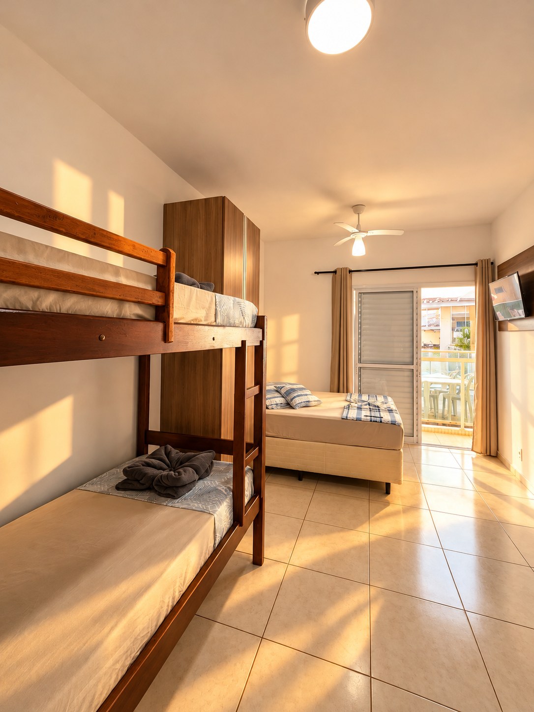 Quarto com beliche, TV e varanda ensolarada
